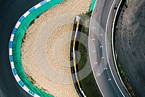 Aerial top down drone view of a racing track with tight turns and hairpins