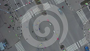 Aerial top down shot of city road intersection with people running at marathon