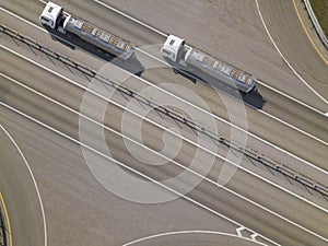 Aerial top down shot of highway with oil truck trailers.