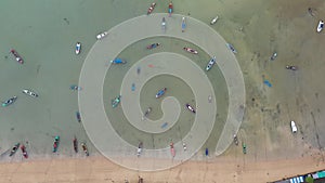 .Aerial top down view on the beach with lot of fisherman and tourist boats floating .