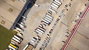 Aerial top down view of Cargo truck Containers and Distribution Warehouse.