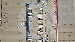 Aerial top down view of Cargo trucks and Containers at Distribution Warehouse.