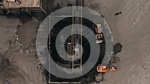 Aerial top down view of coal conveyor belt piling up coal at a depot. Fossil fuel reliance, sustainability and global