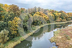 Aerial of colorful autumn forest and small river