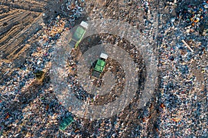 Aerial top down view of garbage trucks unload pile of waste at landfill. Dump of unsorted waste garbage pile in trash photo