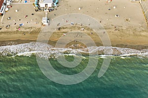 Aerial top down view of Italian resort beach with sand and foaming sea waves at sunset. Ostia Lido near Rome, Italy photo