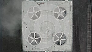 Aerial top down view of large industrial rotating fans located on the roof of a factory floor. Ventilation cooling
