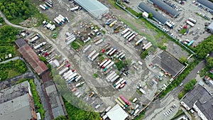 Aerial top down view of mining vehicle parking lot located at a steel making production plant showing dusty and dirty parked haul