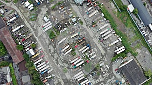 Aerial top down view of mining vehicle parking lot located at a steel making production plant showing dusty and dirty parked haul