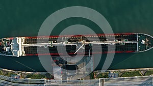 Aerial top down view oil ship tanker vessel loading in gas and oil terminal station refinery, Global trading import
