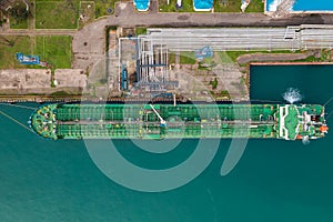 Aerial top down view oil ship tanker vessel loading in gas and oil terminal station refinery, Global trading import