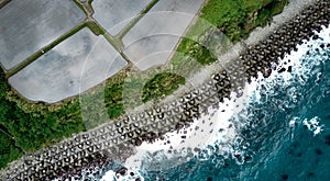 Aerial top-down view on rice paddy fields full of water next to the ocean blue waters