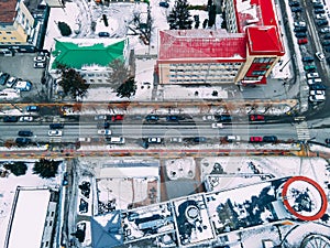 Aerial top down view of road in small european city with snow covered roofs