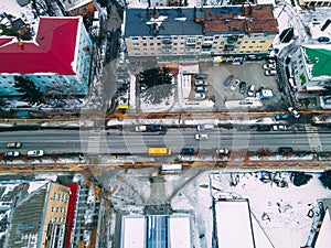 Aerial top down view of road in small european city with snow covered roofs