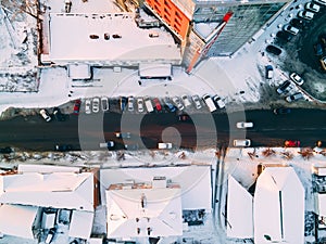 Aerial top down view of road in small european city with snow covered roofs