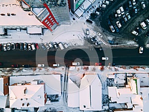 Aerial top down view of road in small european city with snow covered roofs