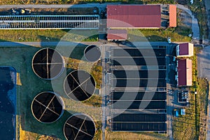 Aerial top down view of sewage treatment plant. Industrial water treatment with round water tanks for sewage recycling