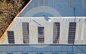 Aerial top down view of solar panel photovoltaic cells on roof of factory, UK