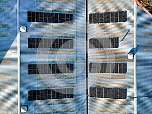 Aerial top down view of solar panel photovoltaic cells on roof of factory, UK