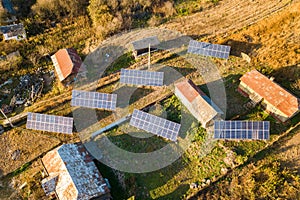 Aerial top down view of solar photo voltaic panels in green rural area. Clean renewable energy in private village environment