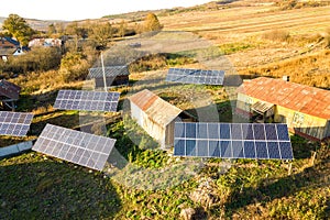 Aerial top down view of solar photo voltaic panels in green rural area. Clean renewable energy in private village environment