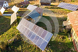 Aerial top down view of solar photo voltaic panels in green rural area. Clean renewable energy in private village environment