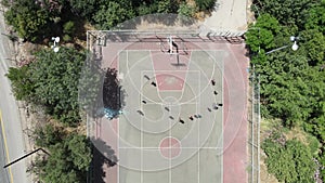 Aerial Top Down View of Street Basketball court and A group of children play football