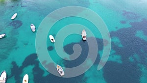 Aerial top down view to small white boats in turquoise water of the sea