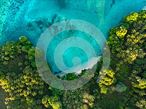 Aerial top down view tropical paradise pristine beach rainforest blue lagoon at Banda Island, Pulau Ay. Indonesia Moluccas photo