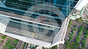 Aerial top down view of window cleaners working on a glass facade modern skyscraper