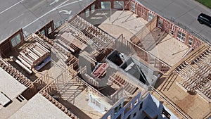 Aerial top down wide view of wood frames and foundations of houses under construction