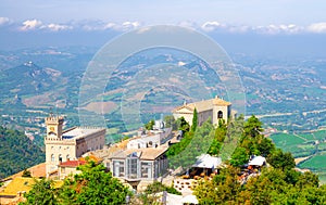 Aerial top panoramic view of Basilica, Palazzo Pubblico palace and landscape with valley, green hills of Republic San Marino