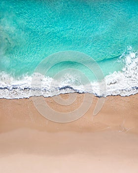 Aerial top shot of a beach with nice sand, blue turquoise water and tropical vibe