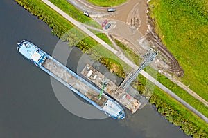 Aerial top shot from freighter unloading sand in the countryside from Netherlands