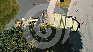 Aerial top shot of Maintenance worker loading cut tree branches into the wood chipper machine for shredding