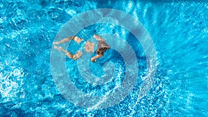 Aerial top view of active woman in swimming pool from above, girl swims in blue water, tropical vacation, holiday on resort