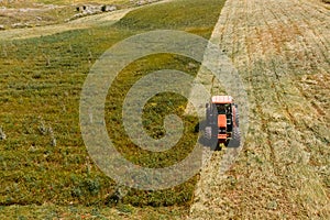 Aerial top view agriculture, tractor removes mowing green grass field