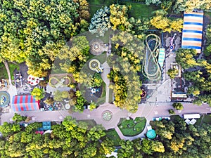 Aerial top view of amusement park and trees at summer morning