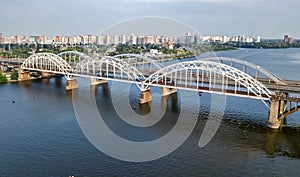 Aerial top view of automobile and railroad Darnitsky bridge across Dnieper river from above, Kiev Kyiv city skyline, Ukraine