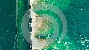 Aerial top view on the beach bay. Umbrellas, sand and sea waves. Summer holidays.