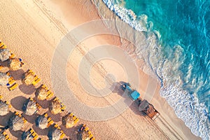 Aerial top view on the beach. Umbrellas, sand and sea waves