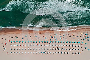 Aerial top view on the beach. Umbrellas, sand and sea waves