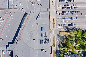 Aerial top view of big shopping mall roof and parking lot