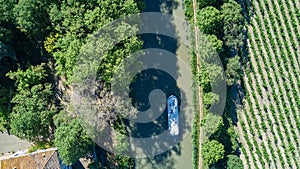 Aerial top view of boat in Canal du Midi from above, family travel by barge and vacation in France