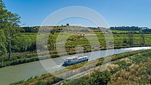 Aerial top view of boat in Canal du Midi from above, family travel by barge and vacation in France