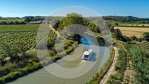 Aerial top view of boat in Canal du Midi from above, travel by barge in Southern France