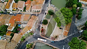 Aerial top view of boats and lock in Canal du Midi, road and bridge from above, France