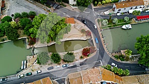 Aerial top view of boats and lock in Canal du Midi, road and bridge from above, France