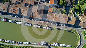 Aerial top view of boats and lock in Canal du Midi, road and bridge from above, in Southern France