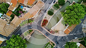 Aerial top view of boats and lock in Canal du Midi, road and bridge from above, in Southern France